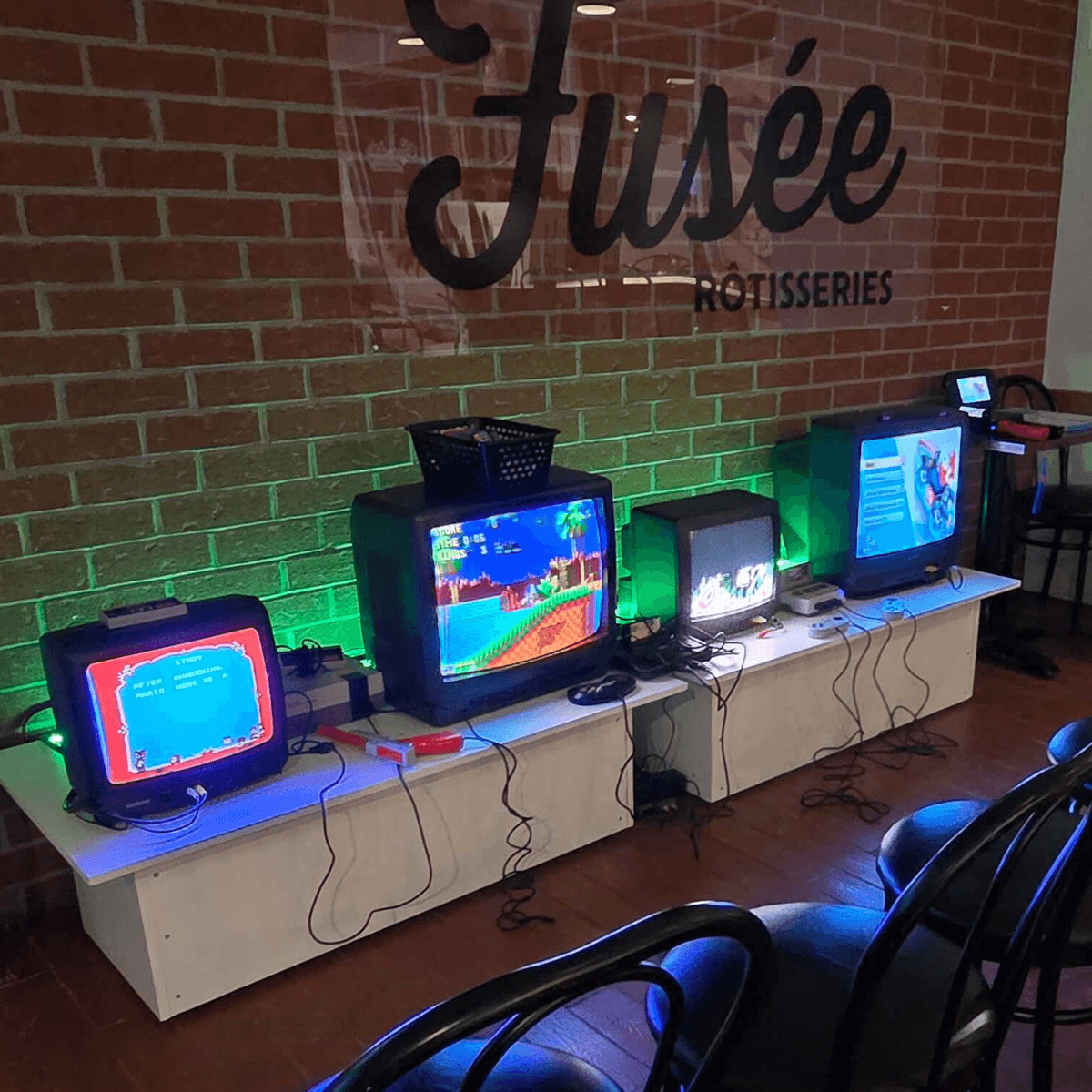 Bornes d'arcade Totalement Geek installées devant un mur de briques dans un espace événementiel